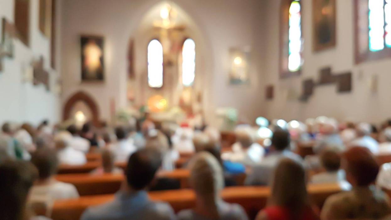 inside of a small church with stained glass windows and pews full of people