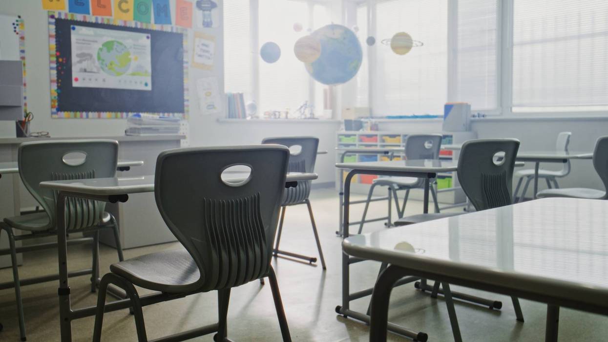Interior of Modern Primary School Classroom with Desks, Chalkboard, Hanging Models of Solar System