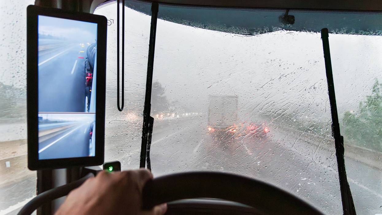 Interior truck view with windshield covered by intense rain, road visibility reduced, and wipers struggling against the storm.Stormy day on the road