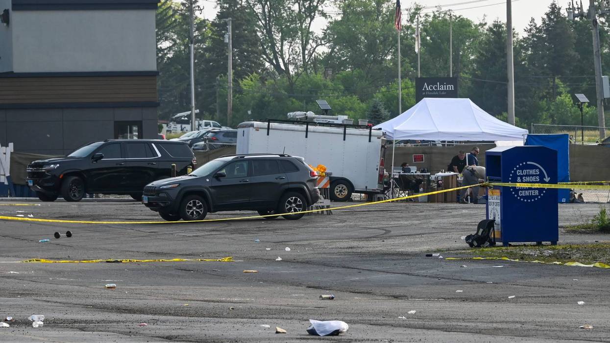 Investigators look over the scene of an overnight mass shooting at a strip mall in suburban Chicago, Sunday, June 18, 2023.