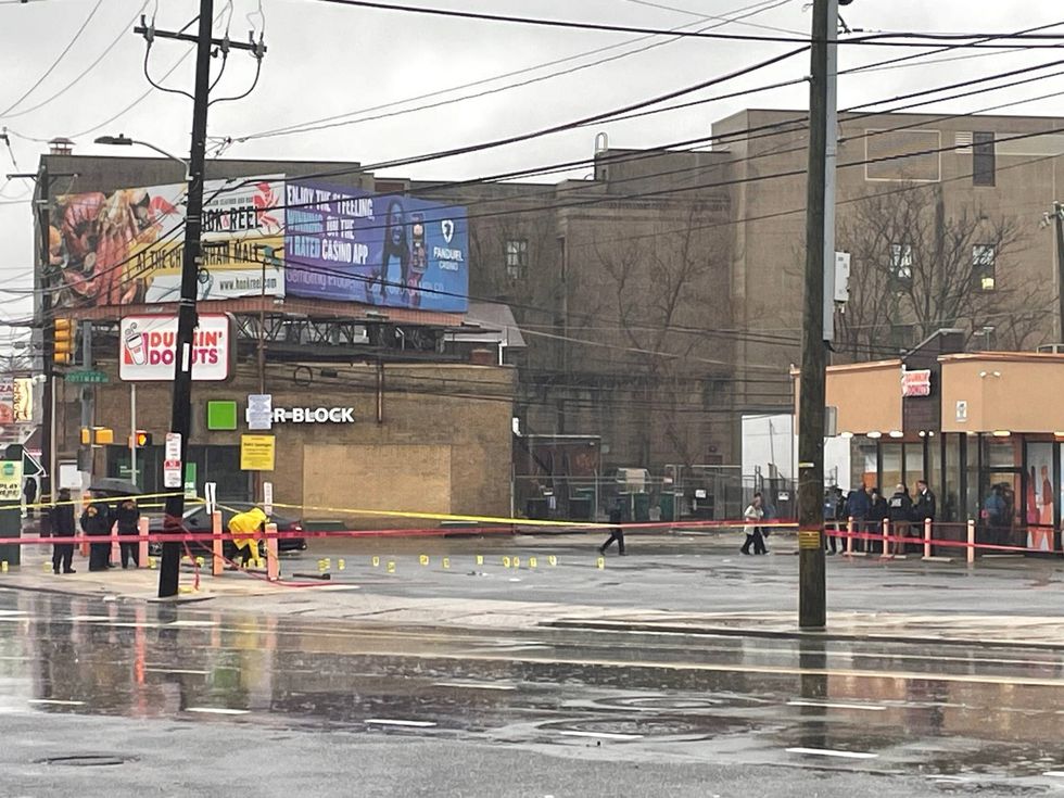 Investigators marked off more than 30 rounds, fired by three masked gunmen into a crowd of students waiting at the bus stop in front of this Dunkin