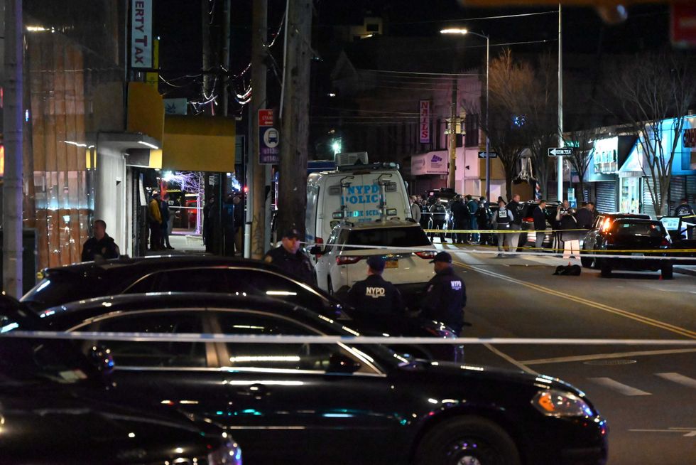 Investigators scour the area of Mott Avenue for evidence Monday night after the shooting