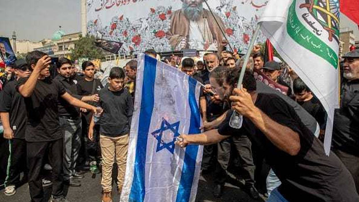 Iranians burn a representation of the Israeli flag during the funeral ceremony of Hamas leader Ismail Haniyeh and his bodyguard who were killed in an assassination blamed on Israel on Wednesday, at Enqelab-e-Eslami (Islamic Revolution) Sq. on August 1, 2024 in Tehran, Iran.