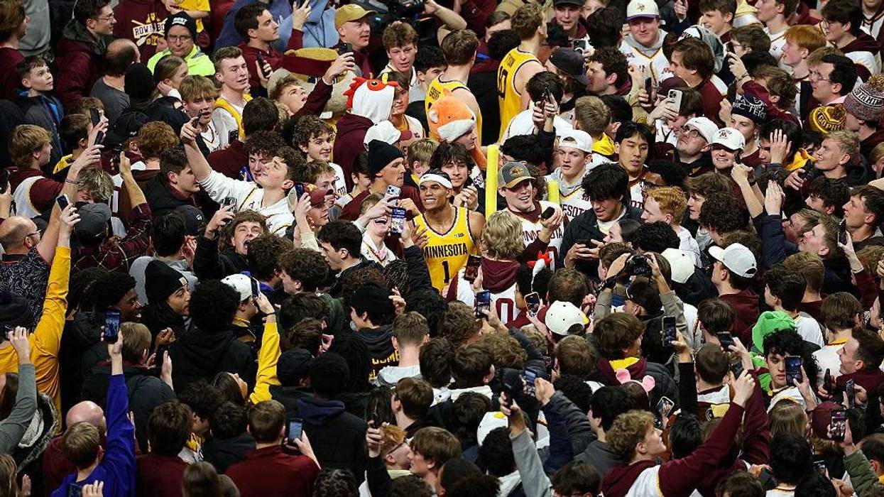 Isaac Asuma #1 of the Minnesota Golden Gophers (C) celebrates the win as fans storm the court after the game against the Michigan State Spartans at Williams Arena on February 04, 2026 in Minneapolis, Minnesota. The Golden Gophers defeated the Spartans 76-73.
