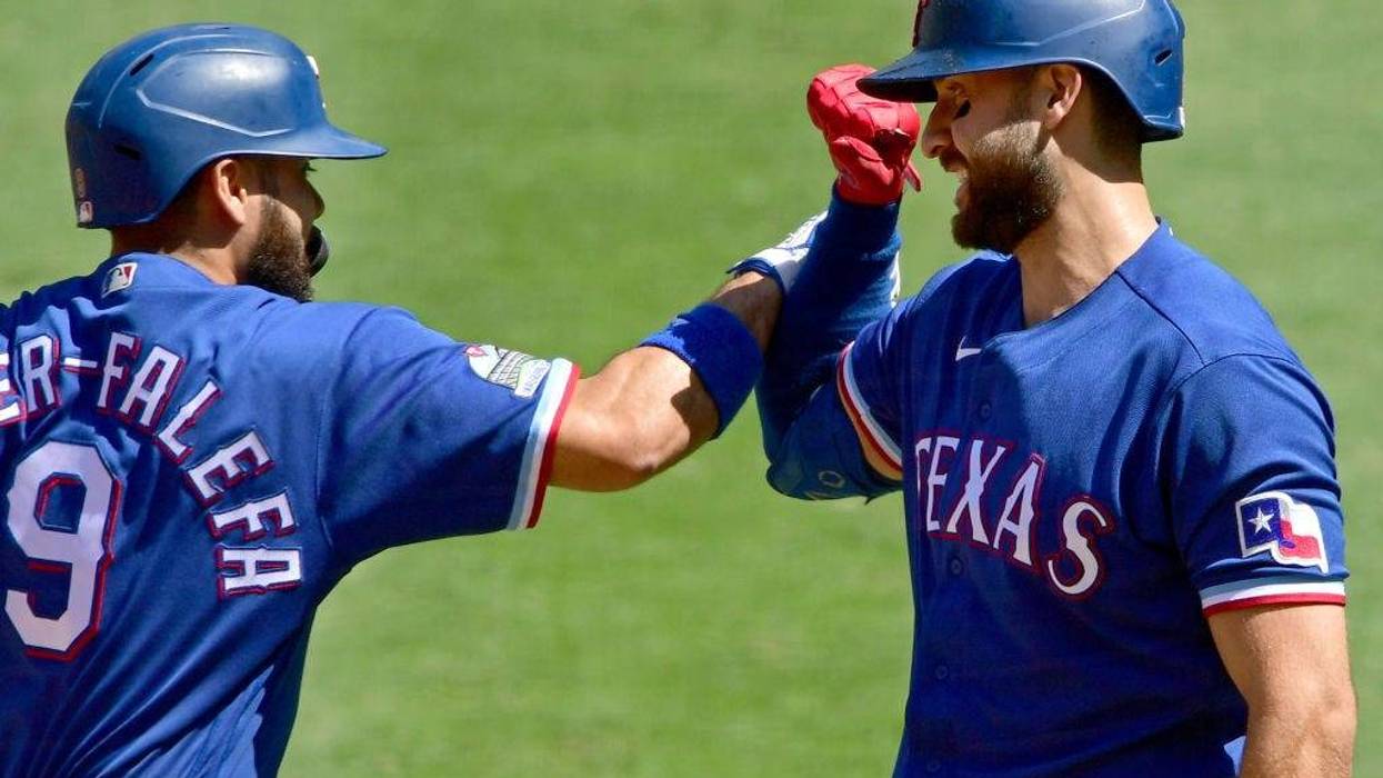 Isiah Kiner-Falefa #9 of the Texas Rangers is congratulated by Joey Gallo #13 after hitting a solo home run in the first inning against the Los Angeles Angels at Angel Stadium of Anaheim on September 21, 2020.