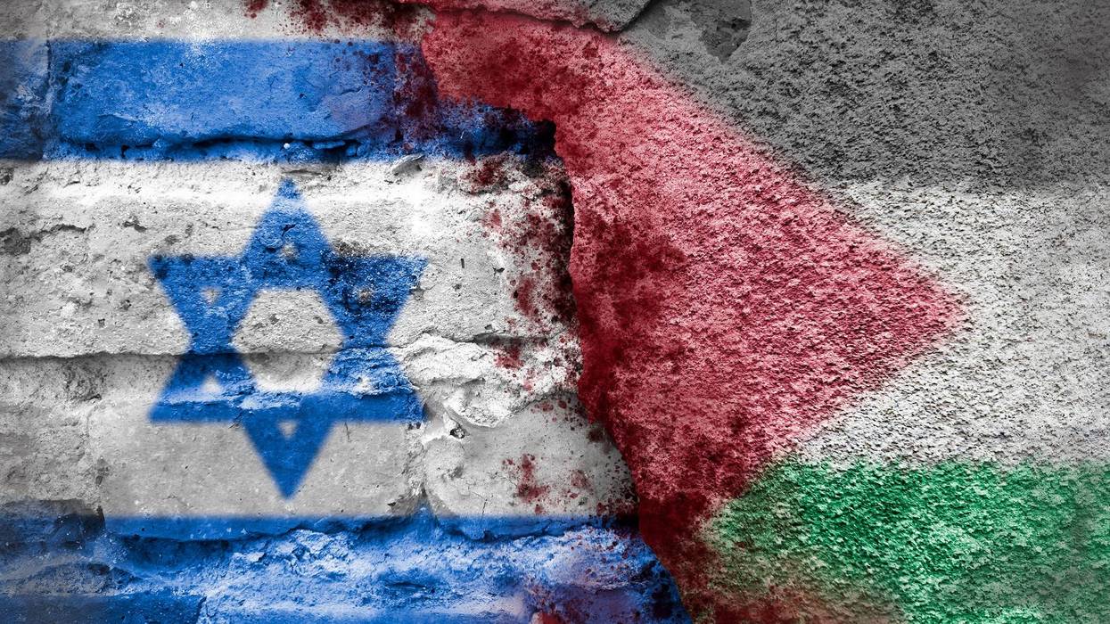 Israeli and Palestinian flags on a brick wall