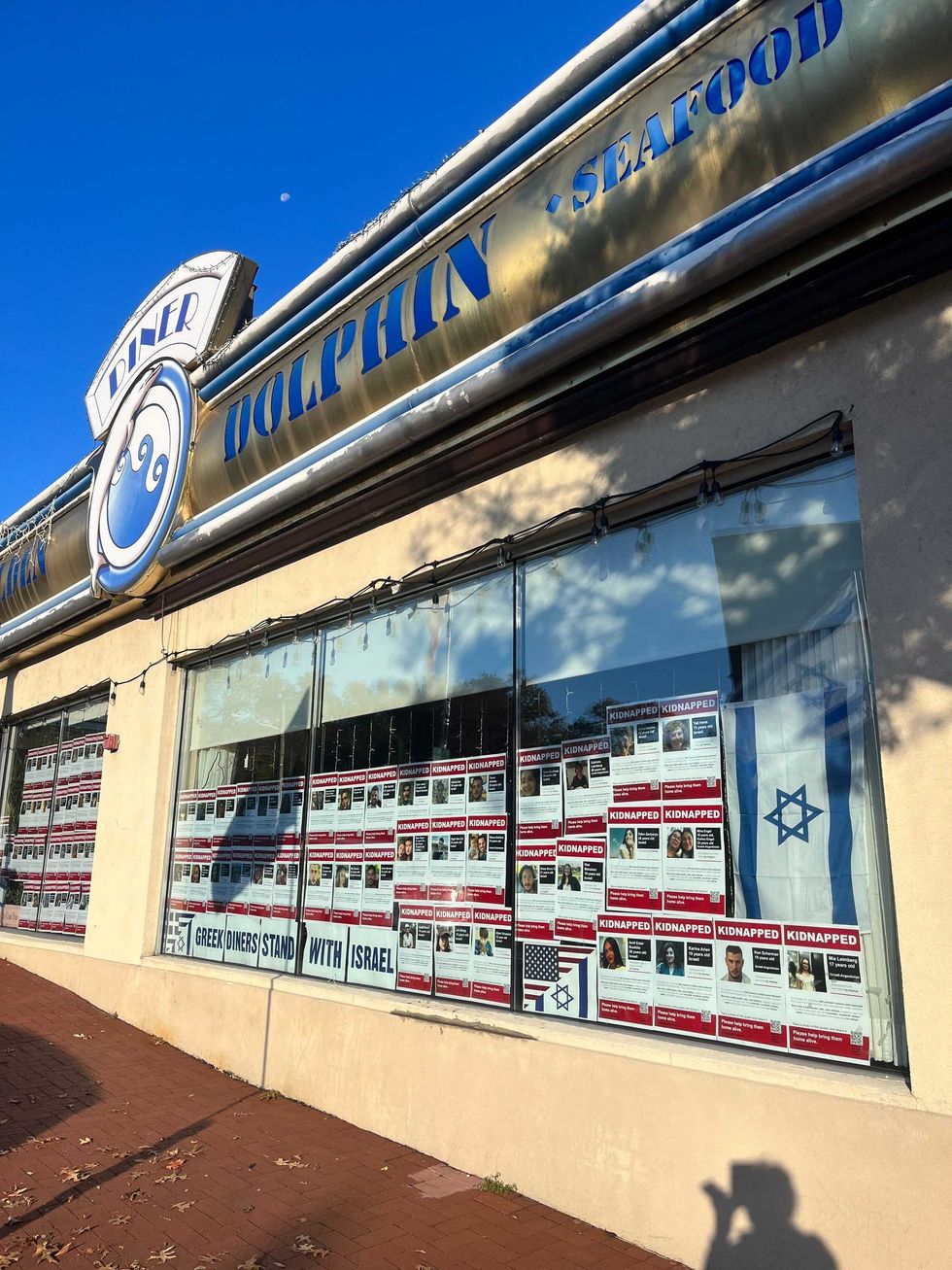Israeli flags and the posters of dozens of missing hostages have been placed in the windows of the Golden Globe Diner in Huntington, formerly known as the Golden Dolphin Diner