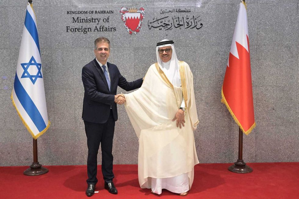 Israeli Foreign Minister Eli Cohen (L), and his Bahraini counterpart Abdullatif bin Rashid Al Zayani (R), shake hands as they hold a joint press conference after taking part in the official opening ceremony for Tel Aviv