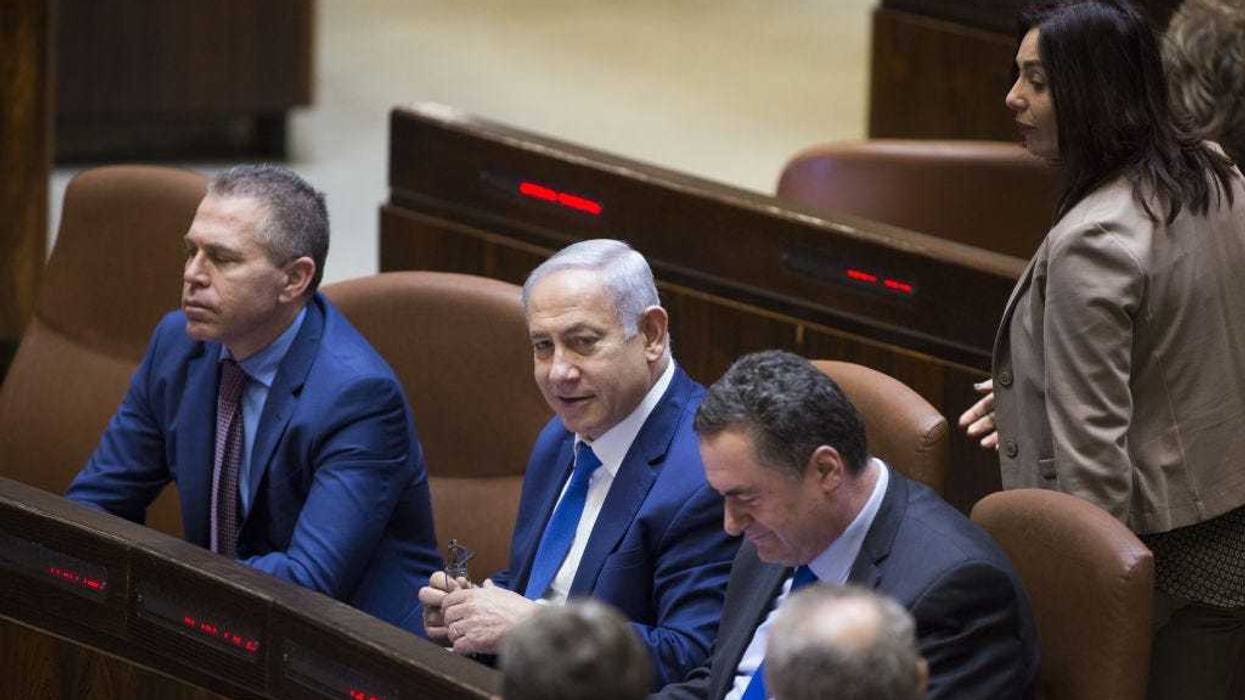 Israeli Prime Minister Benjamin Netanyahu (C) with Israeli Transport Minister Israel Katz (R) and Interior Minister Gilad Erdan (L) attends a discussion to vote on the dissolution of the Israeli Parliament in the Knesset on December 26, 2018 in Jerusalem, Israel.