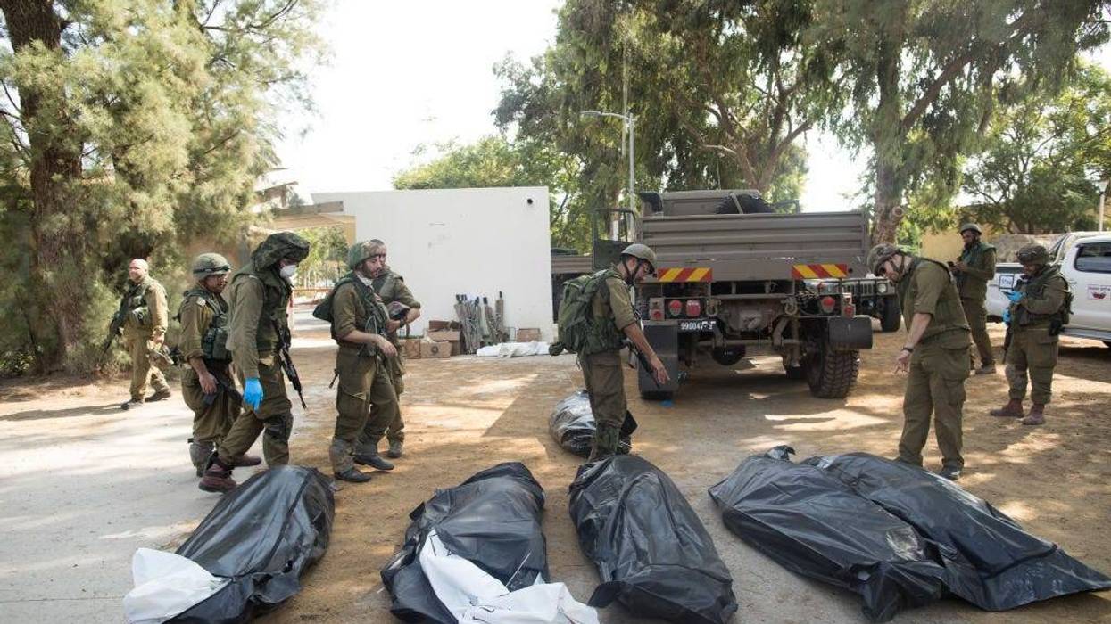 Israeli soldiers remove the bodies of civilians, who were killed days earlier in an attack by Palestinian militants on this kibbutz near the border with Gaza