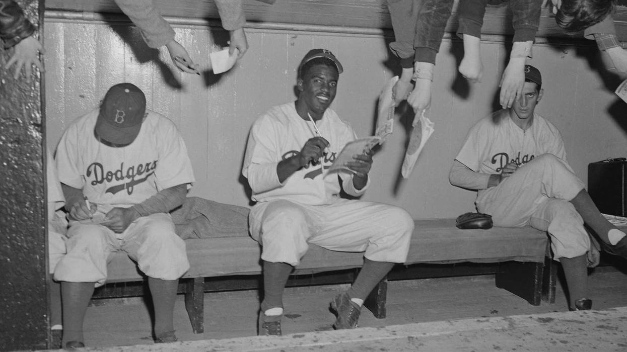 Jackie Robinson and teammates signing autographs for fans in 1949