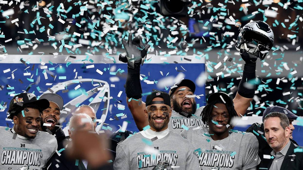 Jalen Hurts #1 of the Philadelphia Eagles and teammates celebrate during the trophy ceremony after their 55-23 win against the Washington Commanders during the NFC Championship Game at Lincoln Financial Field.