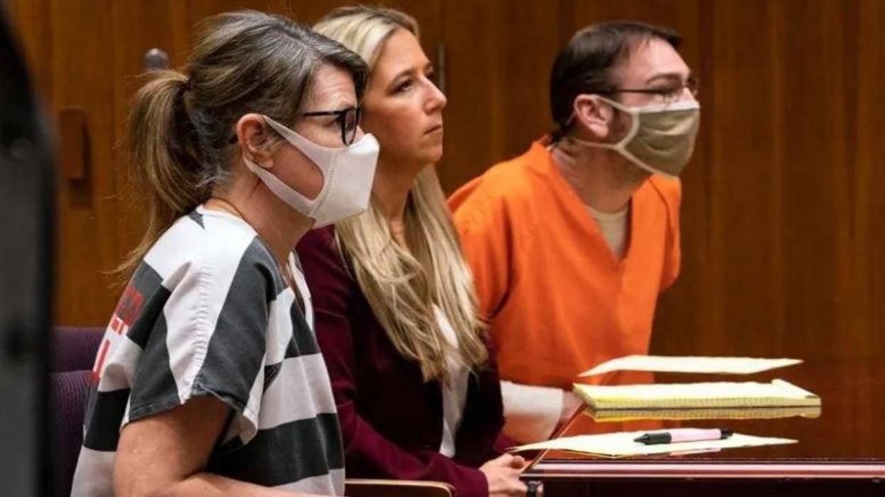 James and Jennifer Crumbley in court with one of their attorneys sitting between them.