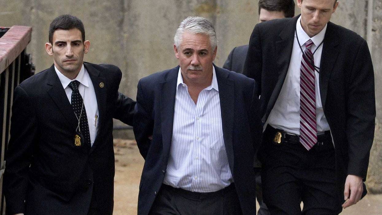 James Burke is escorted to a vehicle by FBI personnel outside the FBI office in Melville on Dec. 9, 2015