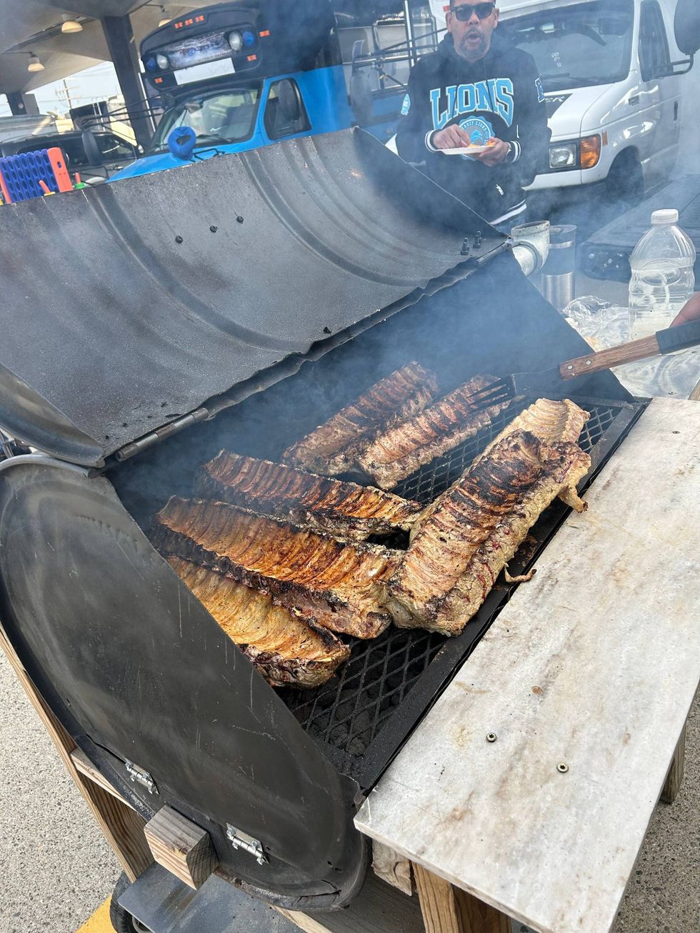 Jamon Hamilton prepares ribs at Eastern Market tailgate ahead of Lions