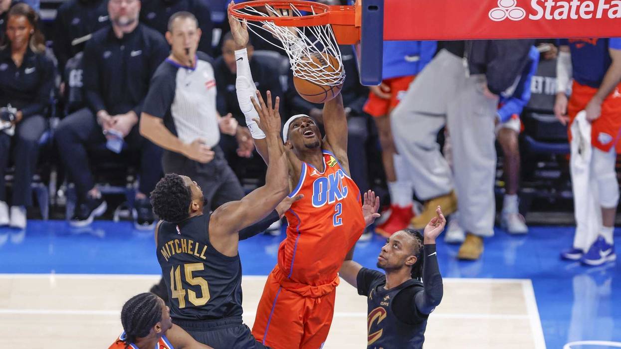 Jan 16, 2025; Oklahoma City, Oklahoma, USA; Oklahoma City Thunder guard Shai Gilgeous-Alexander (2) dunks between Cleveland Cavaliers guard Darius Garland (10) and guard Donovan Mitchell (45) during the fourth quarter at Paycom Center.