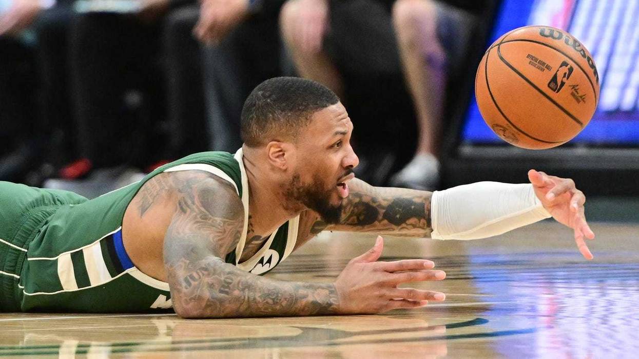 Jan 23, 2025; Milwaukee, Wisconsin, USA; Milwaukee Bucks guard Damian Lillard (0) reaches for a loose ball against the Miami Heat in the first quarter at Fiserv Forum. Mandatory Credit: Benny Sieu-Imagn Images