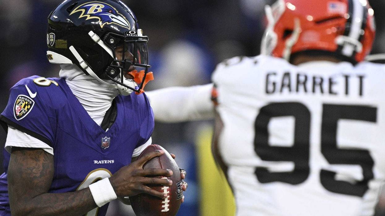 Jan 4, 2025; Baltimore, Maryland, USA; Baltimore Ravens quarterback Lamar Jackson (8) looks to pass as Cleveland Browns defensive end Myles Garrett (95) applies pressure during the first half at M&T Bank Stadium.