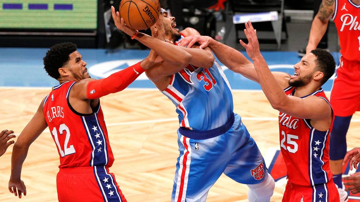 Jarrett Allen #31 of the Brooklyn Nets controls the ball as Tobias Harris #12 and Ben Simmons #25 of the Philadelphia 76ers defend.