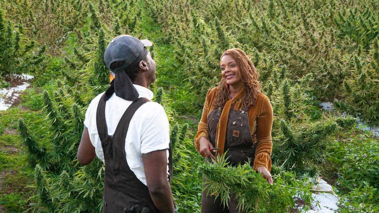 Jasmine Burems and King Aswad standing with their first hemp harvest in 2018.