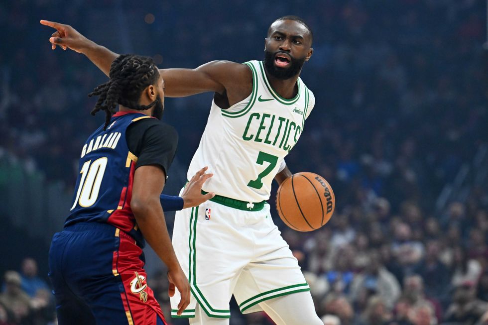 Jaylen Brown #7 of the Boston Celtics yells to a teammate while under pressure from Darius Garland #10 of the Cleveland Cavaliers during the first quarter at Rocket Arena on November 30, 2025 in Cleveland, Ohio.