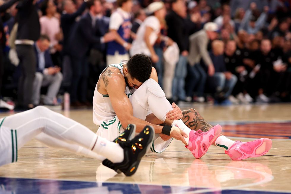 Jayson Tatum #0 of the Boston Celtics holds his ankle on the ground after being injured against the New York Knicks during the fourth quarter in Game Four of the Eastern Conference Second Round NBA Playoffs at Madison Square Garden on May 12, 2025 in New York City.