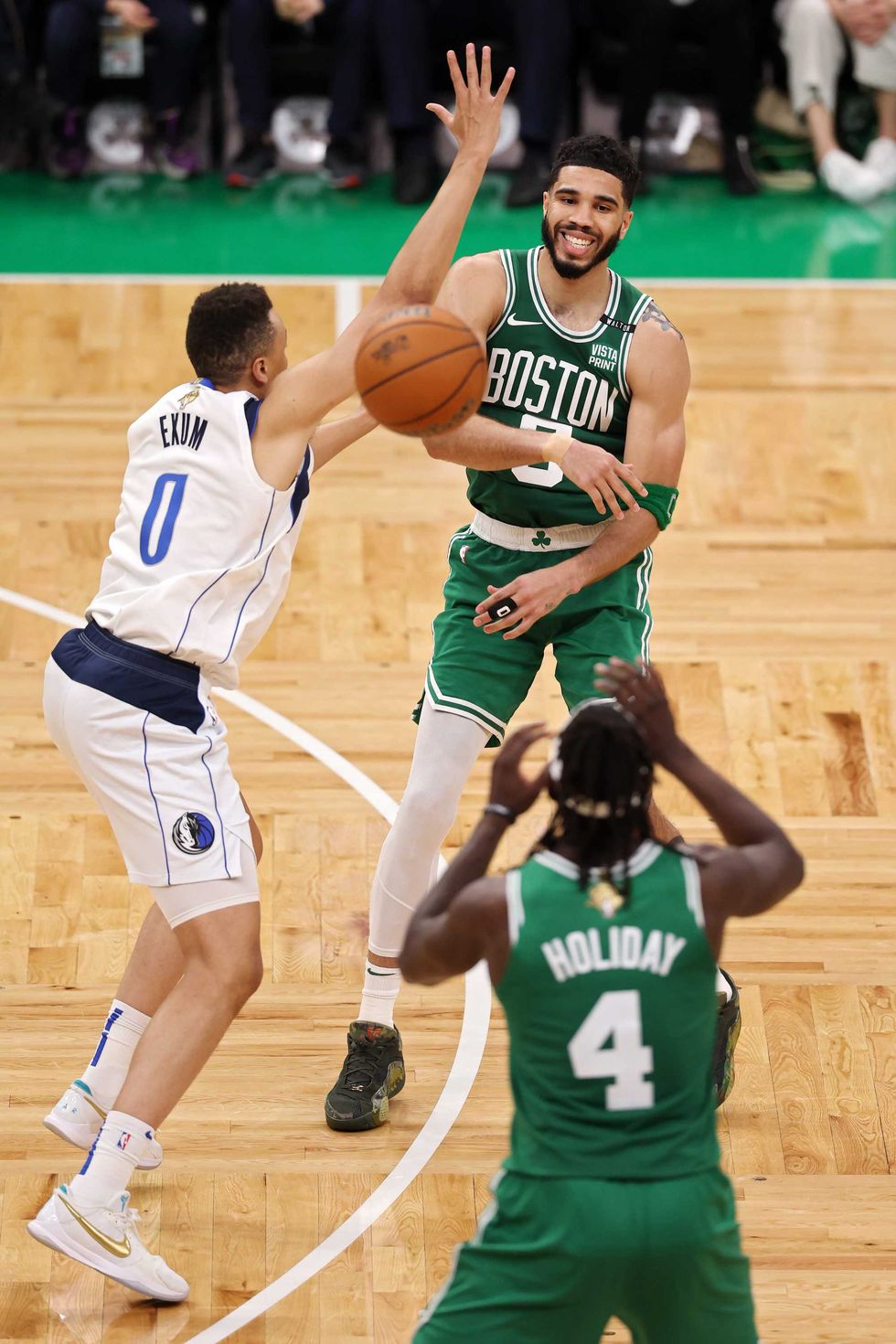 Jayson Tatum #0 of the Boston Celtics passes the ball to Jrue Holiday #4 of the Boston Celtics over Dante Exum #0 of the Dallas Mavericks during the third quarter of Game Five of the 2024 NBA Finals at TD Garden on June 17, 2024 in Boston, Massachusetts.