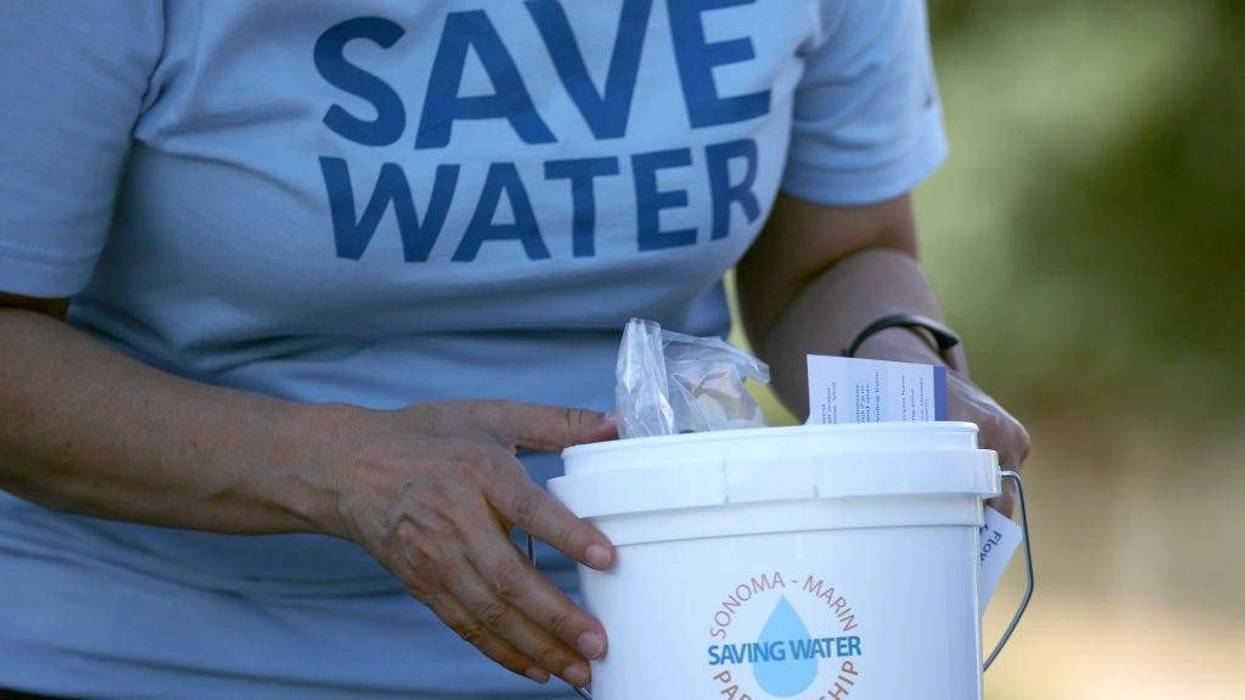 Jeanne Mariani-Belding with the Marin Municipal Water District (MMWD) prepares to hand out a bucket filled with information on the drought and water saving tools during a "Drought Drive Up" event at the MMWD headquarters on June 12, 2021 in Corte Madera, California.