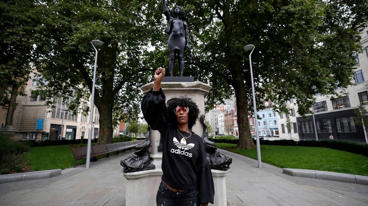 Jen Reid poses for photographs in front of the new black resin and steel statue portraying her, entitled "A Surge of Power (Jen Reid) 2020" by artist Marc Quinn.