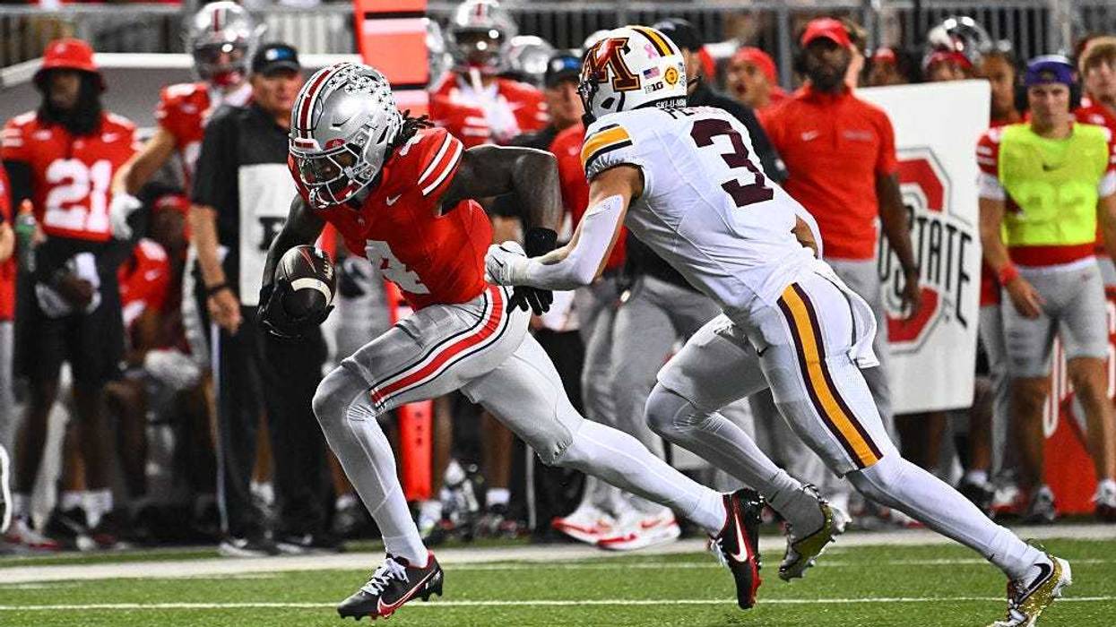 Jeremiah Smith #4 of the Ohio State Buckeyes runs with the ball as Koi Perich #3 of the Minnesota Golden Gophers defends during the first quarter of a game at Ohio Stadium on October 4, 2025 in Columbus, Ohio.