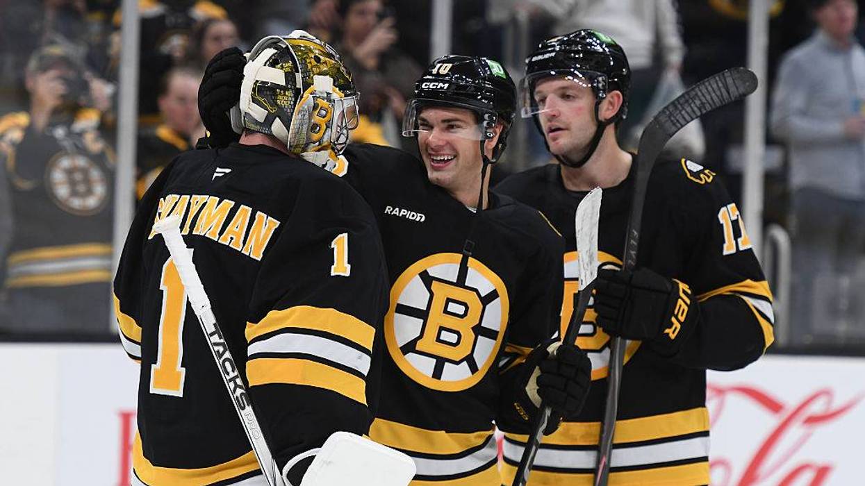Jeremy Swayman, JJ Peterka and Will Borgen celebrate the Bruins' 5-1 win over the Flyers
