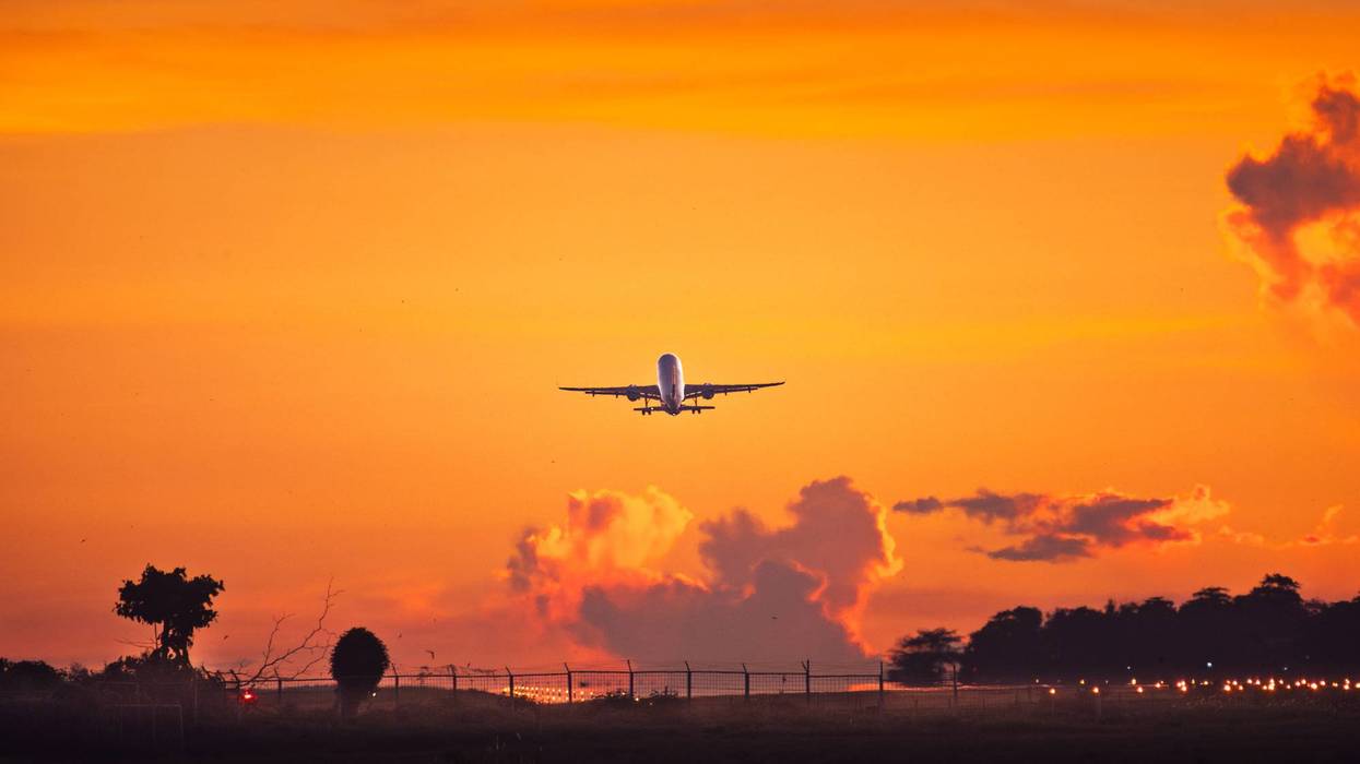 Jet Airliner Ascending into Fiery Sunset Sky