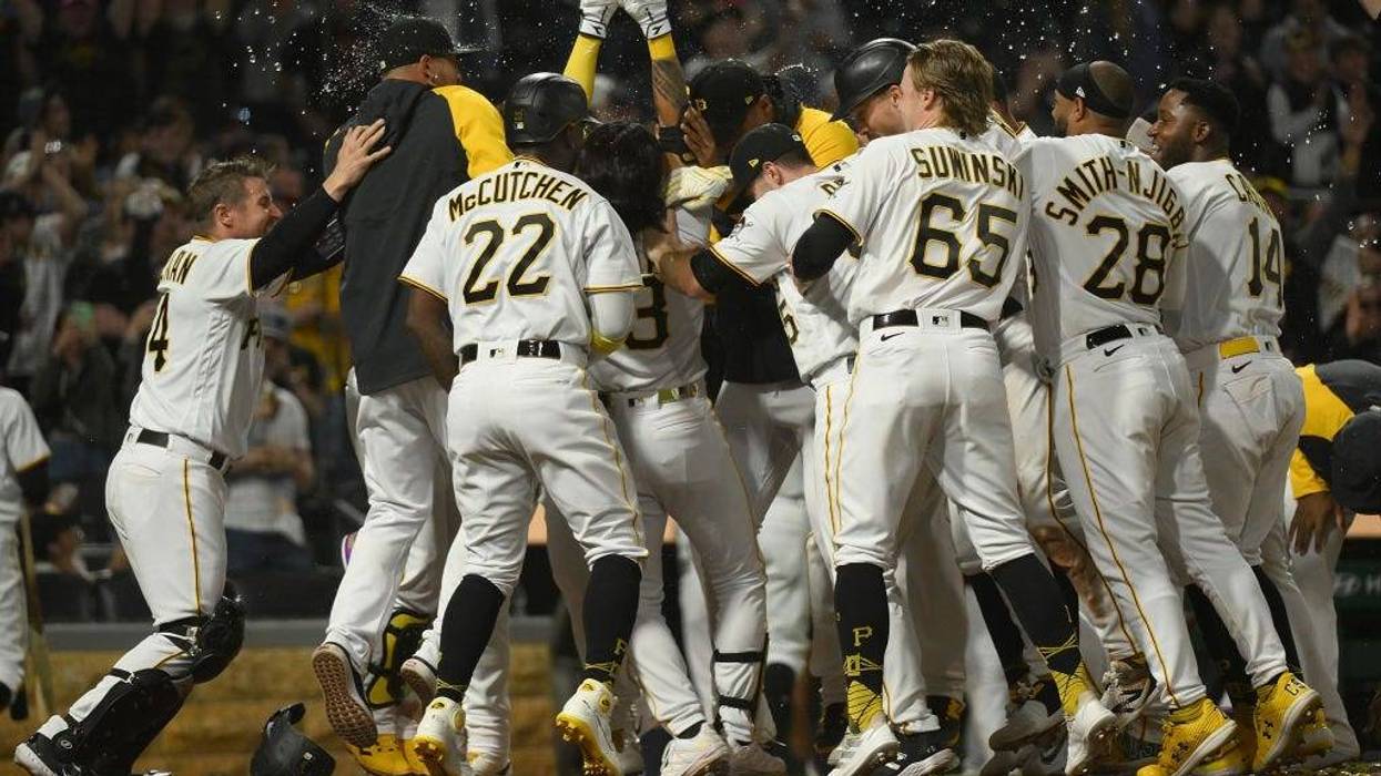 Ji Hwan Bae #3 of the Pittsburgh Pirates is mobbed by teammates after hitting a walk-off three-run home run for a 7-4 win over the Houston Astros at PNC Park