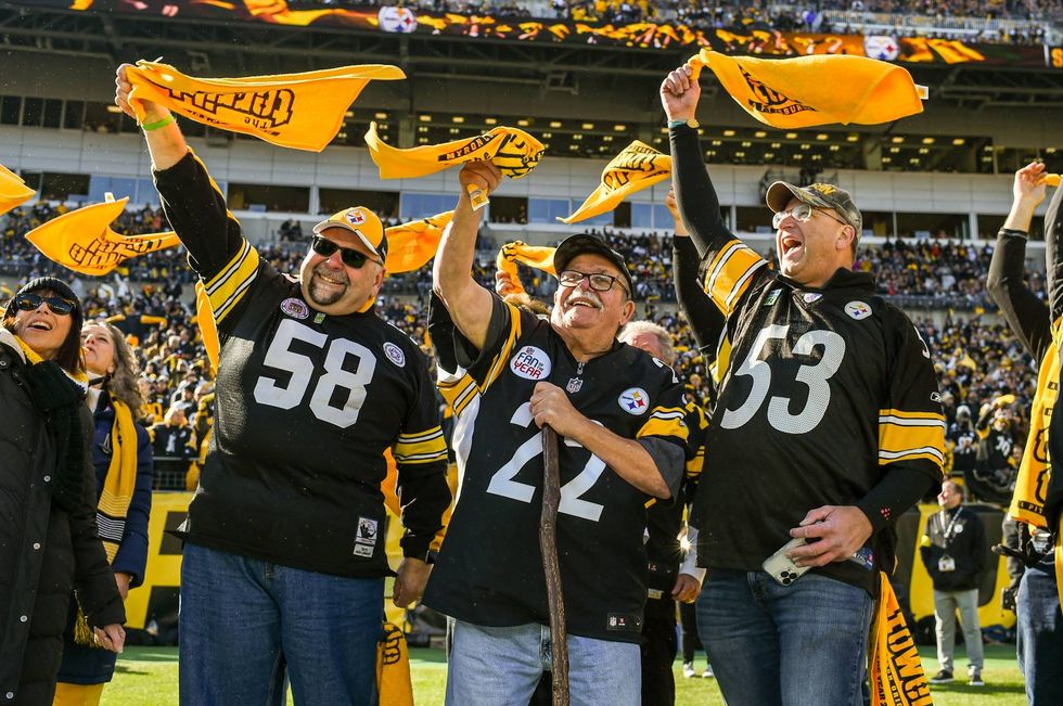 Jim Zimmerman Sr. (center) and Bill Soloway (right) lead the Pittsburgh faithful in waving their Terrible Towels.