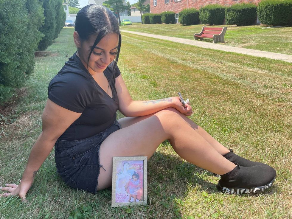 Joan Ortiz looks down at a photo of her daughter, 2-year-old Nikolette Rivera.