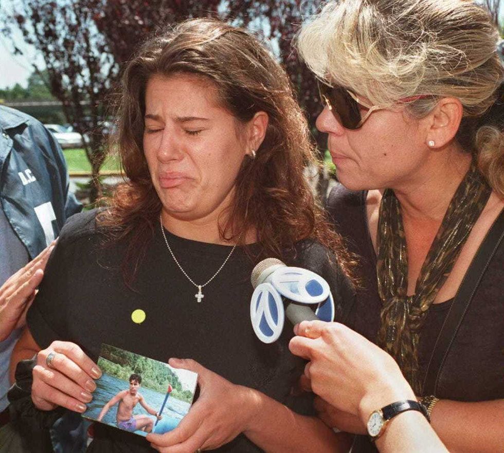 JoAnn Callas(L) cries as she holds a photo of her brother, Daniel J. Callas 20 July outside the Ramada Inn at John F. Kennedy Airport in New York. Daniel Callas was a flight attendant on board TWA flight 800 that exploded July 17, 1996. Callas is comforted by unidentified relative (R).