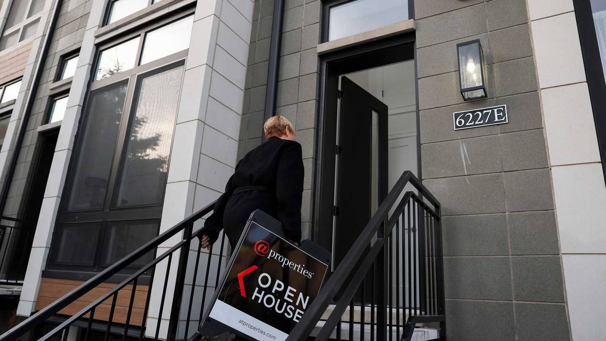 Joanna Olszynska, a Compass real estate broker, brings in a sign at the end of an open house for a single-family row house in Chicago's Woodlawn neighborhood on Jan. 21, 2024.
