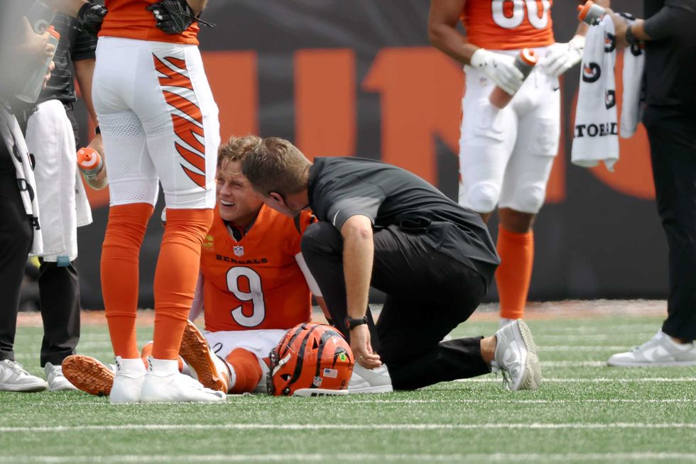 Joe Burrow #9 of the Cincinnati Bengals is looked at by staff following an injury in the second quarter of the game against the Jacksonville Jaguars at Paycor Stadium on September 14, 2025 in Cincinnati, Ohio.