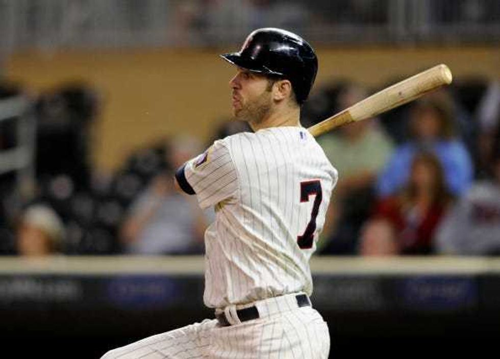 : Joe Mauer #7 of the Minnesota Twins hits an RBI single against the Detroit Tigers during the eighth inning of the game on September 17, 2014 at Target Field in Minneapolis, Minnesota. The Twins defeated the Tigers 8-4.