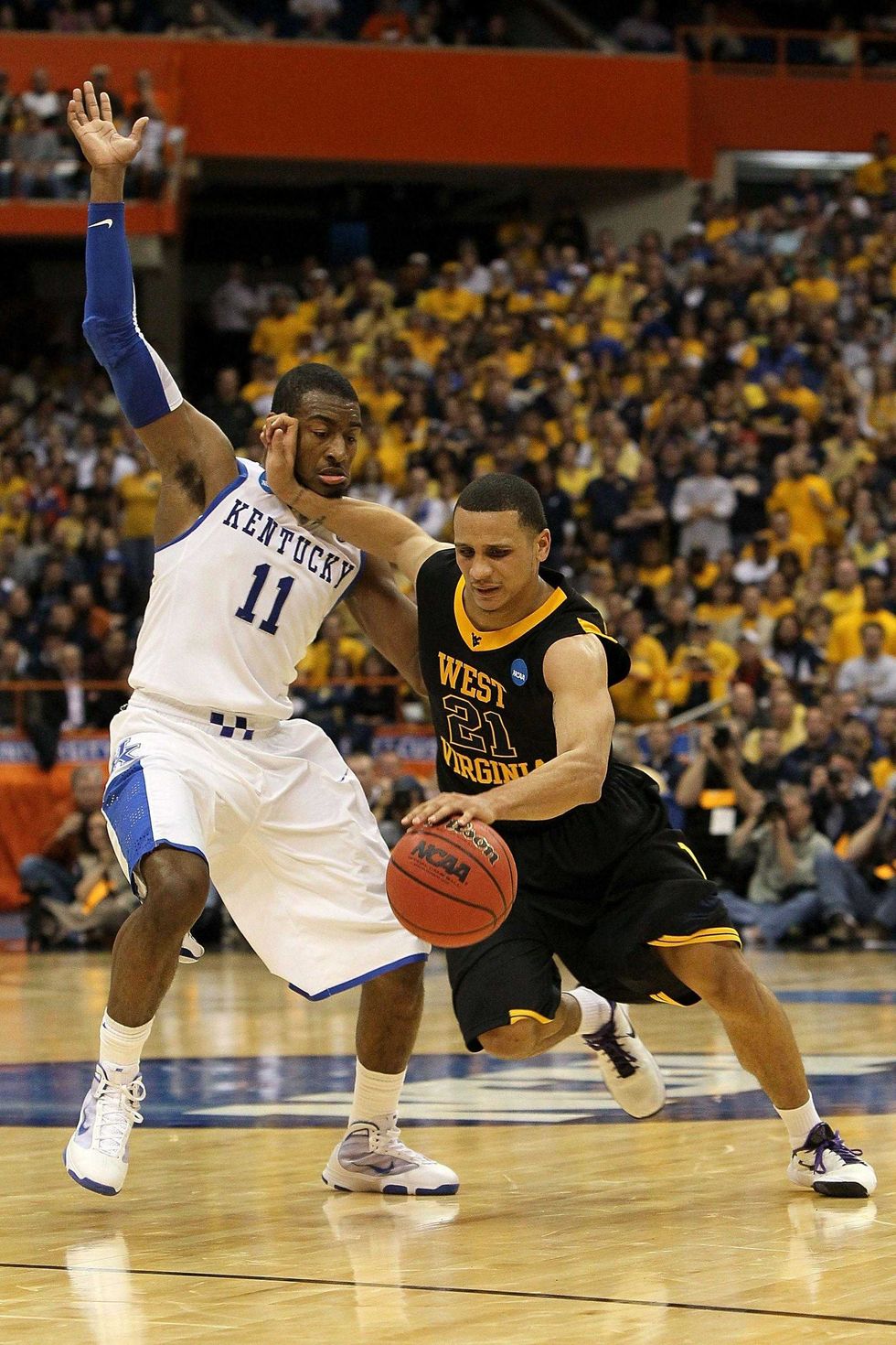 Joe Mazzulla #21 of the West Virginia Mountaineers drives against John Wall #11 of the Kentucky Wildcats during the east regional final of the 2010 NCAA men