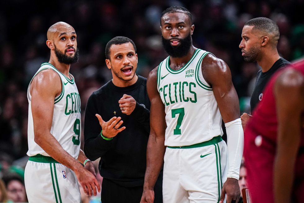 Joe Mazzulla talks with Jaylen Brown (7) and Derrick White (9) from the sideline as they take on the Cleveland Cavaliers at TD Garden.