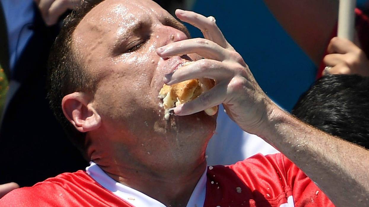 Joey Chestnut stuffs his mouth with hot dogs during the men's competition of Nathan's Famous July Fourth hot dog eating contest, Thursday, July 4, 2019, in New York's Coney Island.