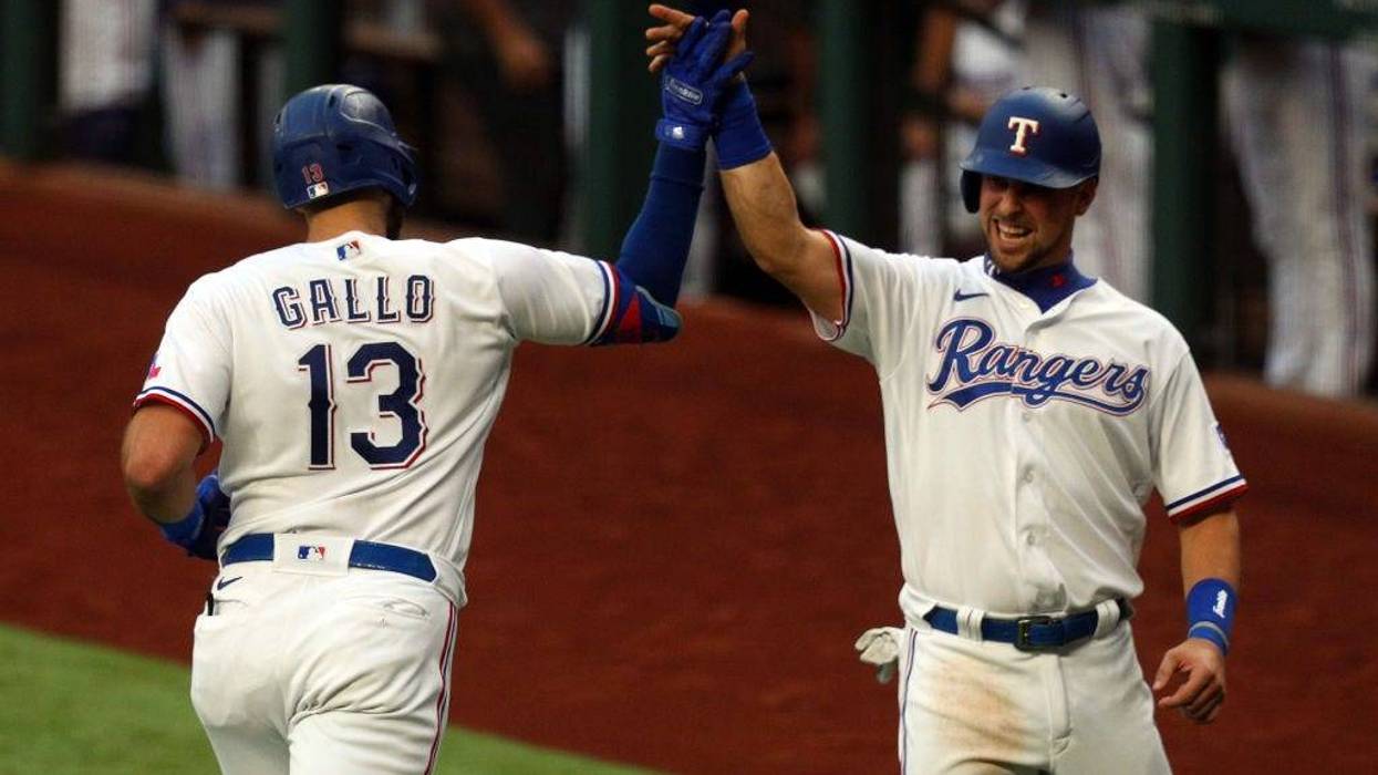 Joey Gallo #13 is greeted by Nate Lowe #30 of the Texas Rangers after a two-run home run by Gallo in the fourth inning against the Seattle Mariners at Globe Life Field on May 08, 2021.