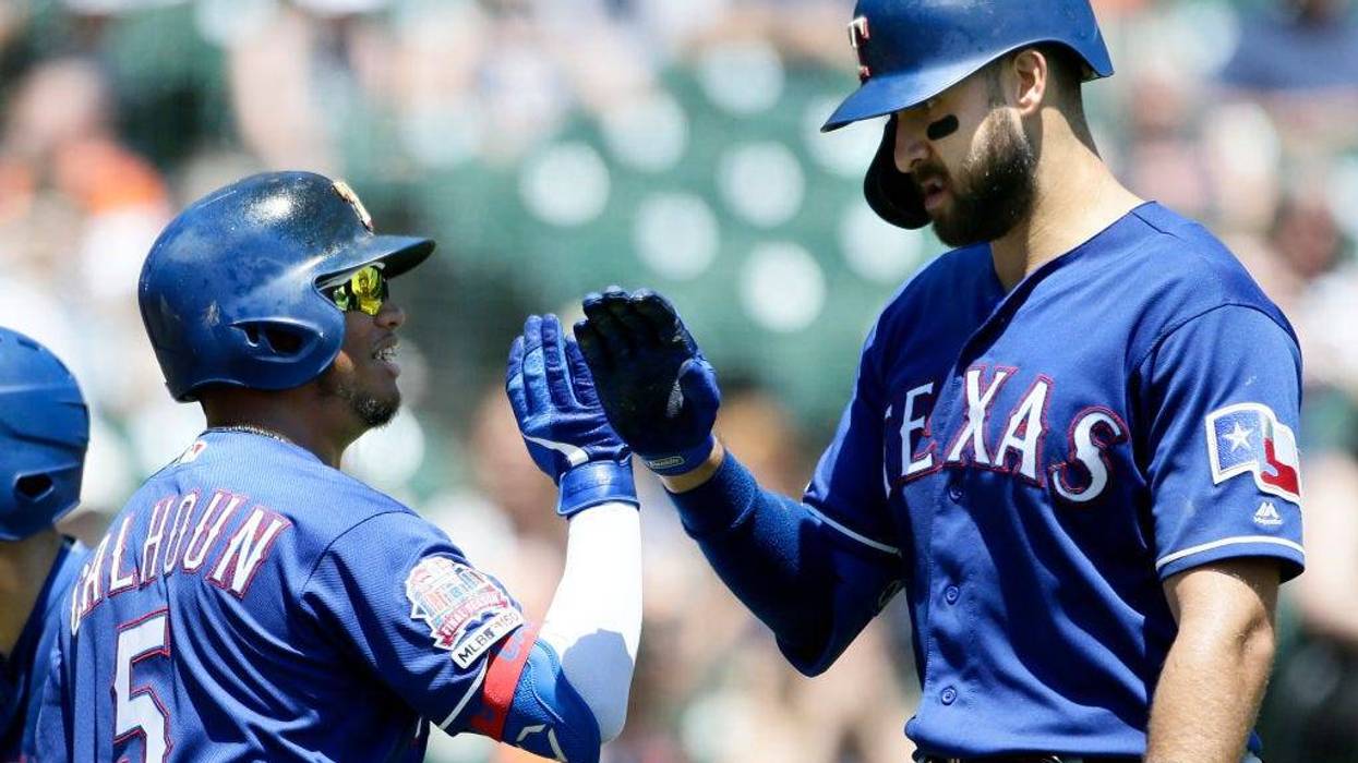 Joey Gallo #13 of the Texas Rangers receives a high-five from Willie Calhoun #5 of the Texas Rangers after hitting a solo home run against the Detroit Tigers during the fourth inning at Comerica Park on June 27, 2019 in Detroit, Michigan.