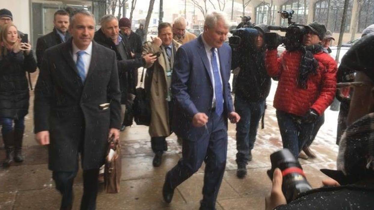 John Dougherty (center) leaves his first court appearance.