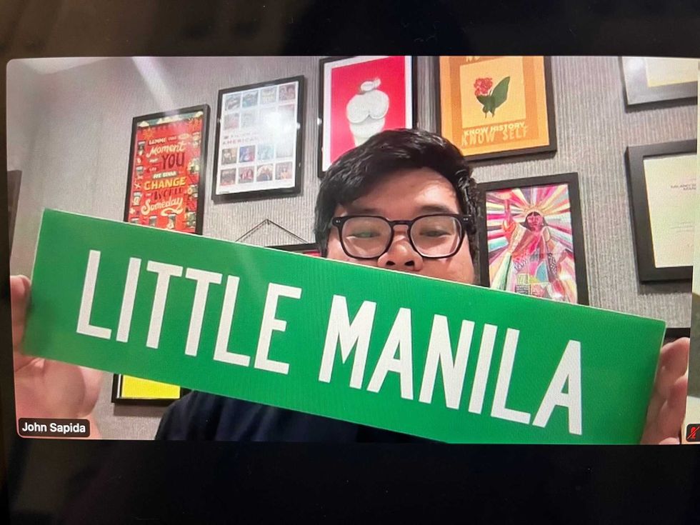 John Sapida holds up a "Little Manila" street sign