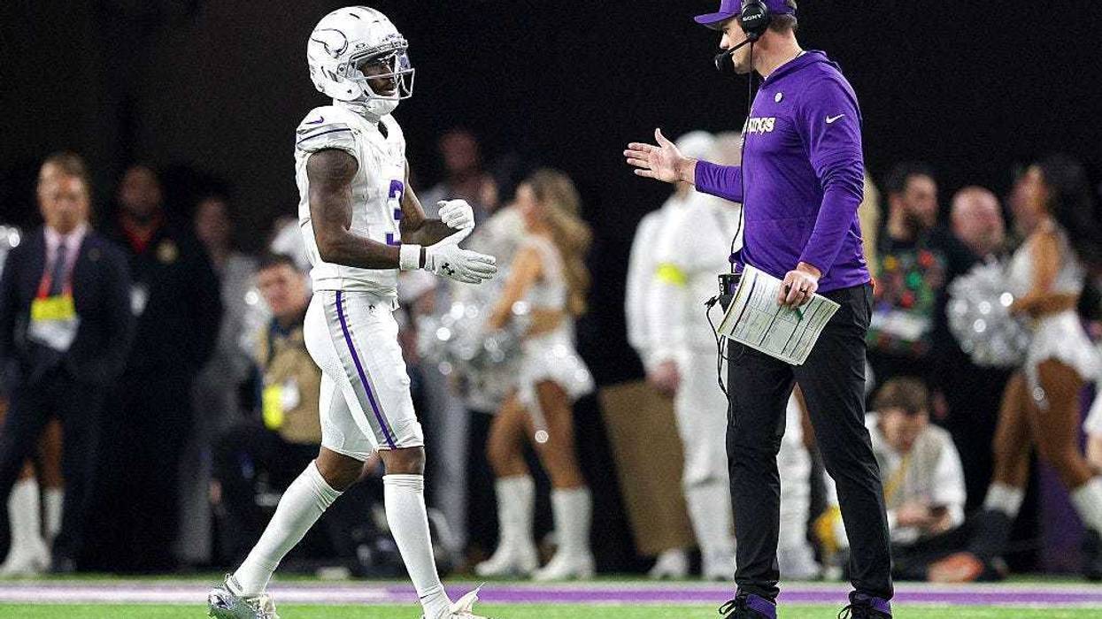Jordan Addison #3 of the Minnesota Vikings is congratulated by head coach Kevin O'Connell after scoring a rushing touchdown against the Detroit Lions during the fourth quarter at U.S. Bank Stadium on December 25, 2025 in Minneapolis, Minnesota.
