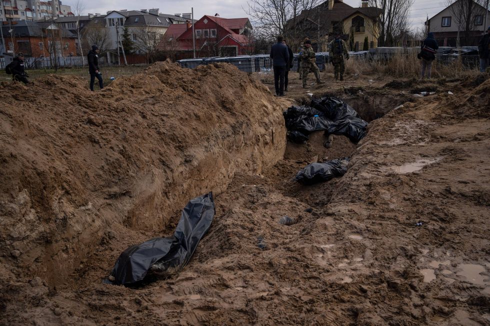 Journalists stand by a mass grave in Bucha, on the outskirts of Kyiv, Ukraine, Monday, April 4, 2022. Russia is facing a fresh wave of condemnation after evidence emerged of what appeared to be deliberate killings of civilians in Ukraine.