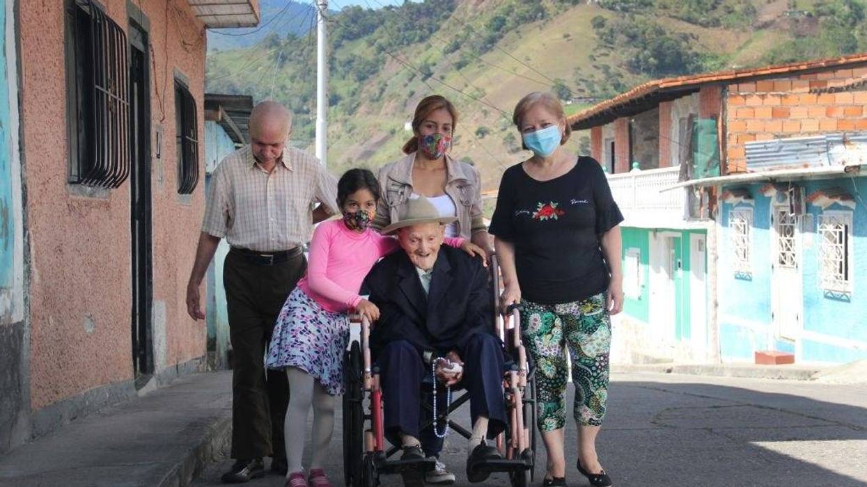 Juan Vicente Mora poses for a photograph with his family in the streets of the town where he currently lives. San José de Bolivar, January 24, 2022