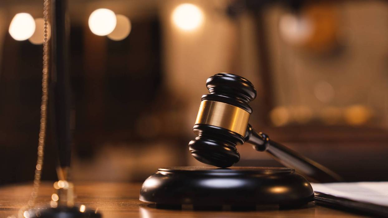 Judge gavel on the table with blurry books in the background